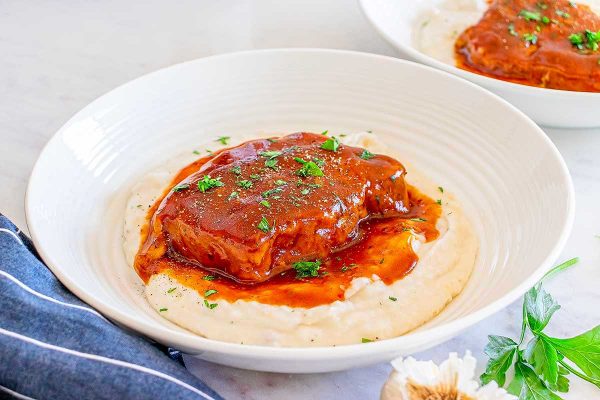 Pork chops with sauce in a white plate. 