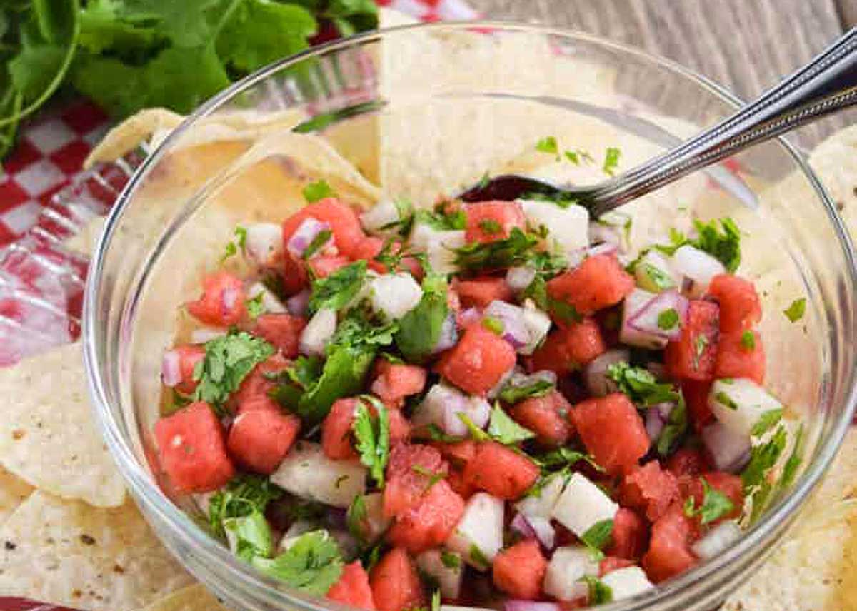 A bowl of homemade salsa served with chips.