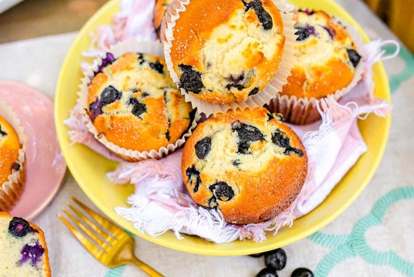 Bakery style blueberry muffins in a bowl.