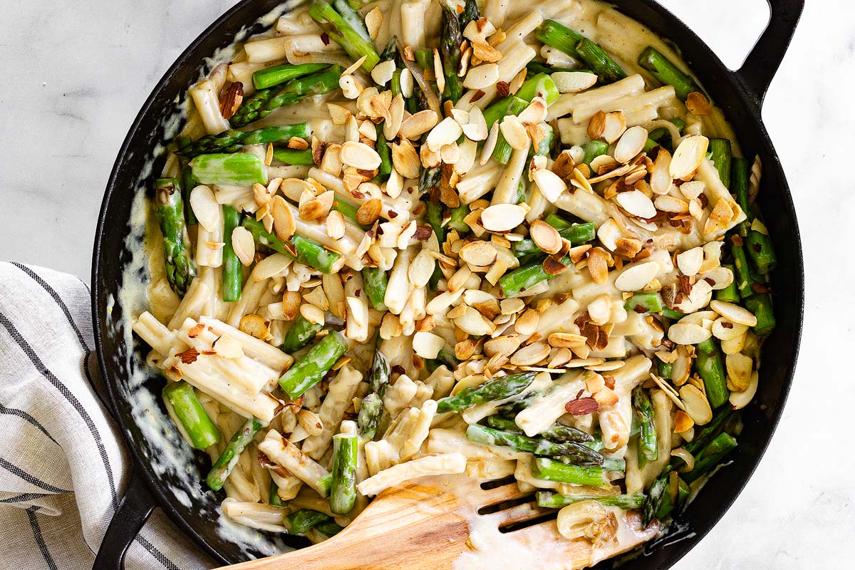 A pasta dish with creamy sauce, asparagus and lemons.