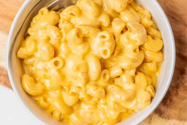 Mac n cheese in a white bowl with cheese.