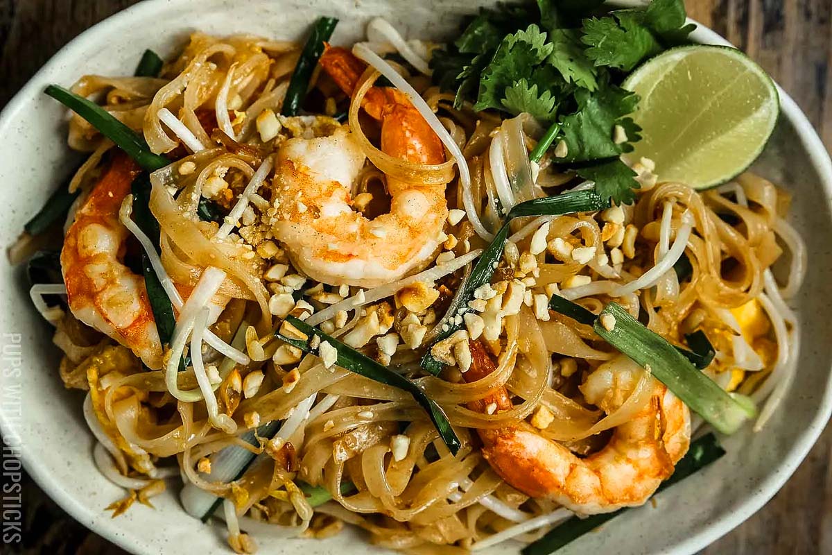 Noodles with shrimp, veggies and nuts sprinkled over the top.