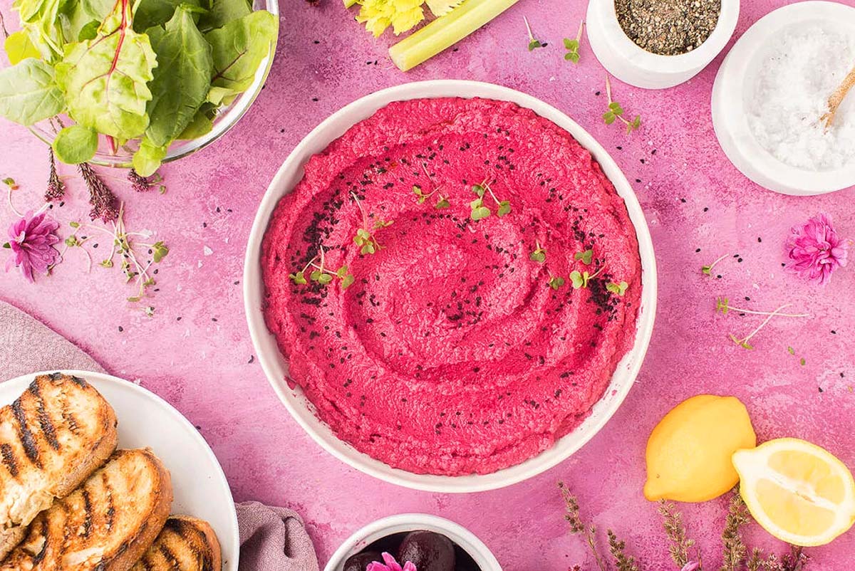 A bright pink beet hummus recipe in a bowl.