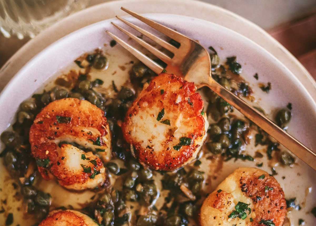 Scallops and a plate with lemon butter.