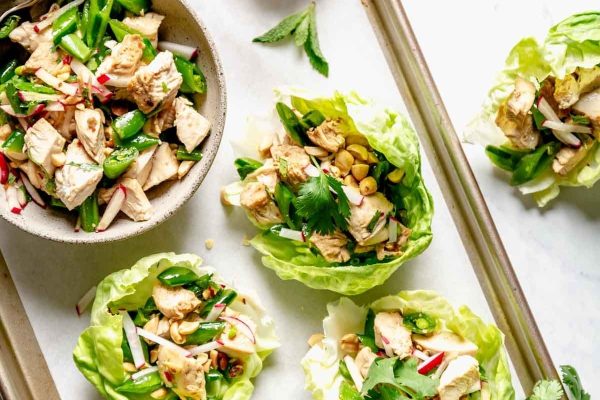 Sesame chicken on lettuce wraps on a sheet pan.
