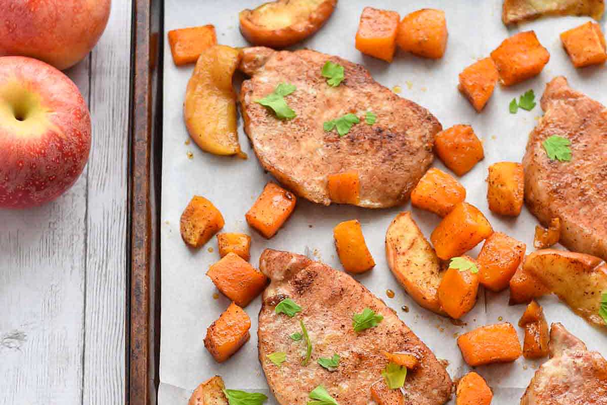 Sheet pan pork chops with butternut squash on a sheet pan.