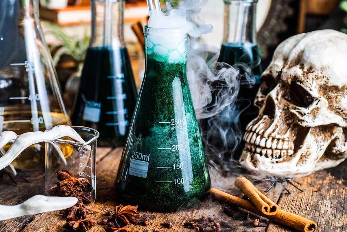Halloween party recipes with a green shimmering punch served in a beaker. 