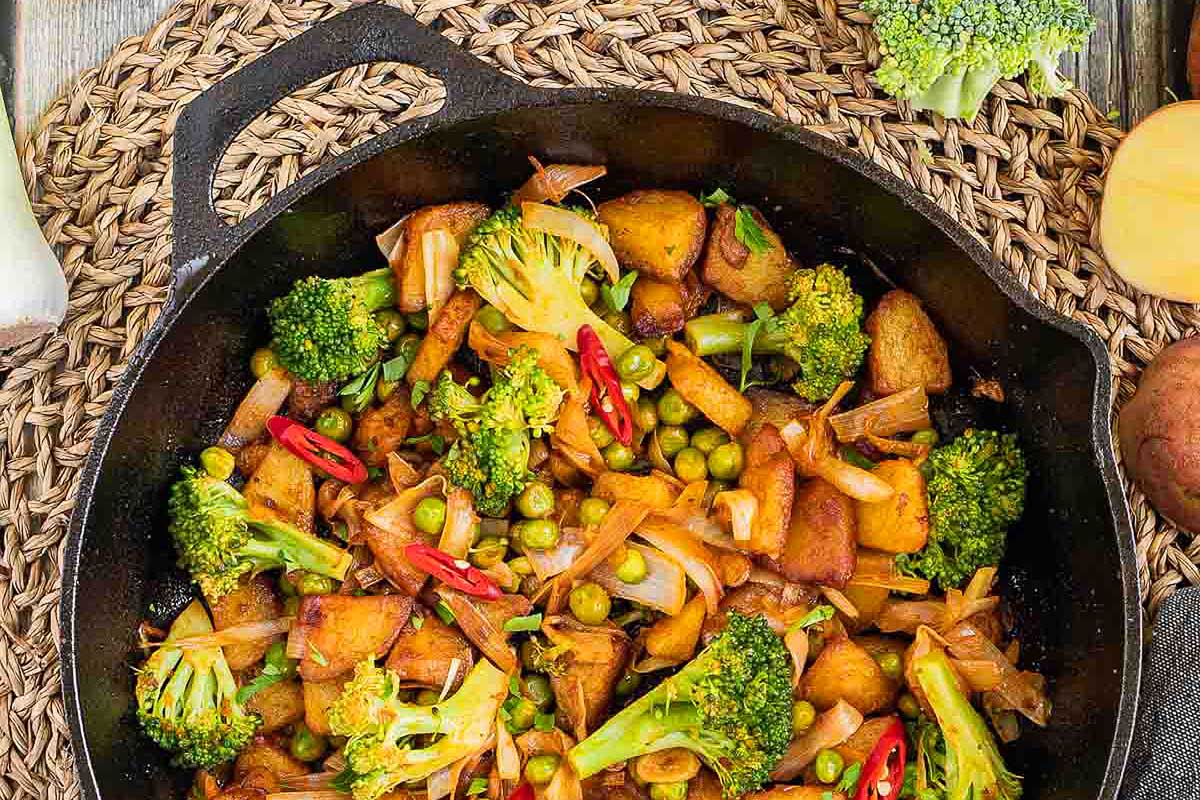 Potatoes and colorful vegetables in a skillet.