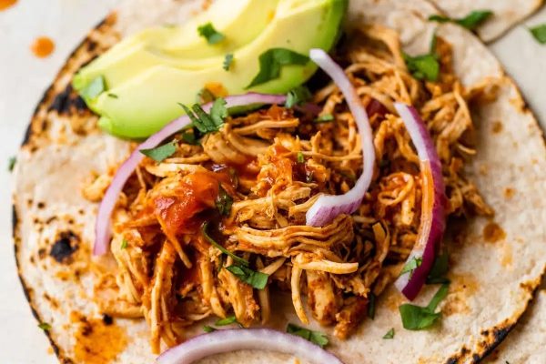 A slow cooker chicken taco on a plate.