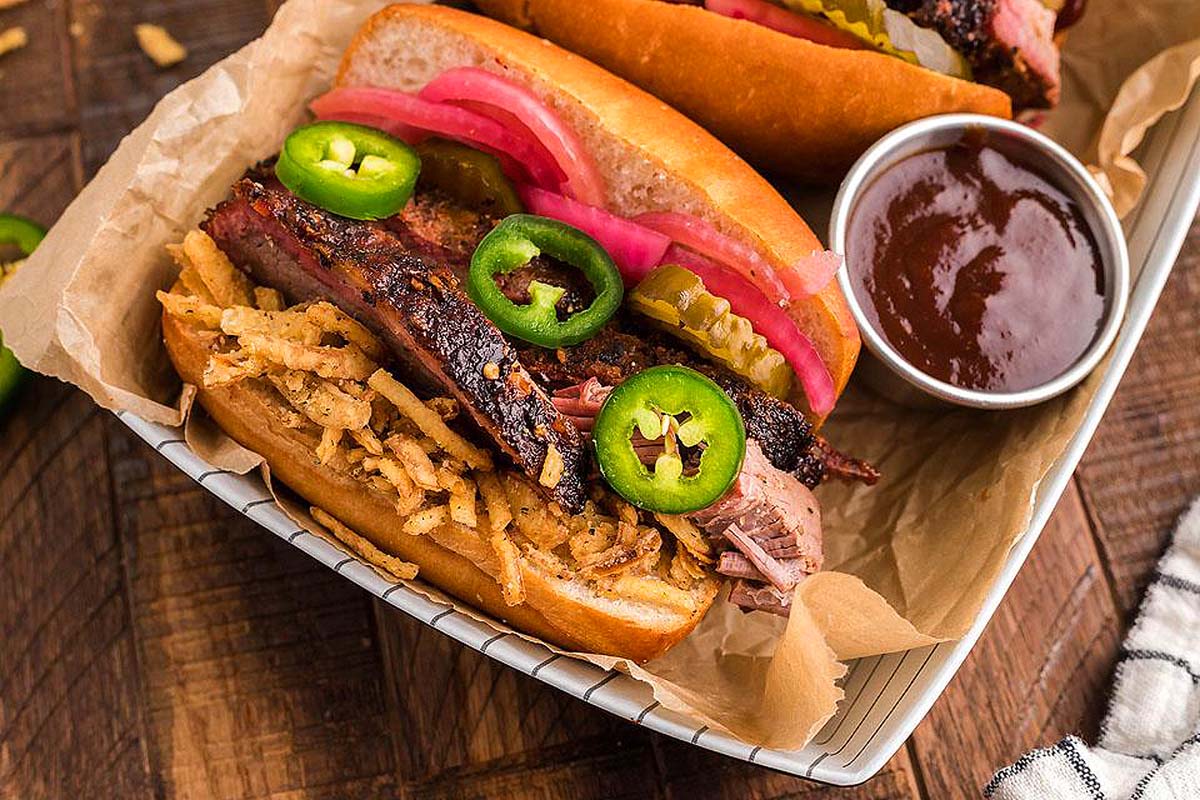 A smoked brisket sandwich in a basket with bbq sauce.