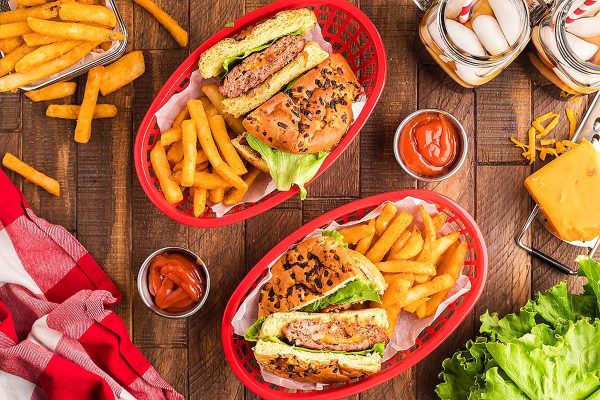 Overhead view of burgers in red baskets.