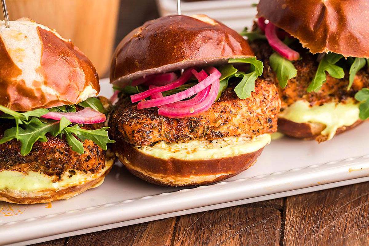 A platter with salmon sliders on it.