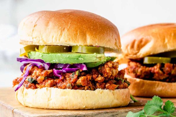 Chicken taco sloppy joe on bun with avocado.