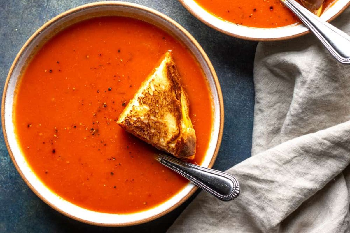 Spicy tomato soup with grilled cheese in a bowl.