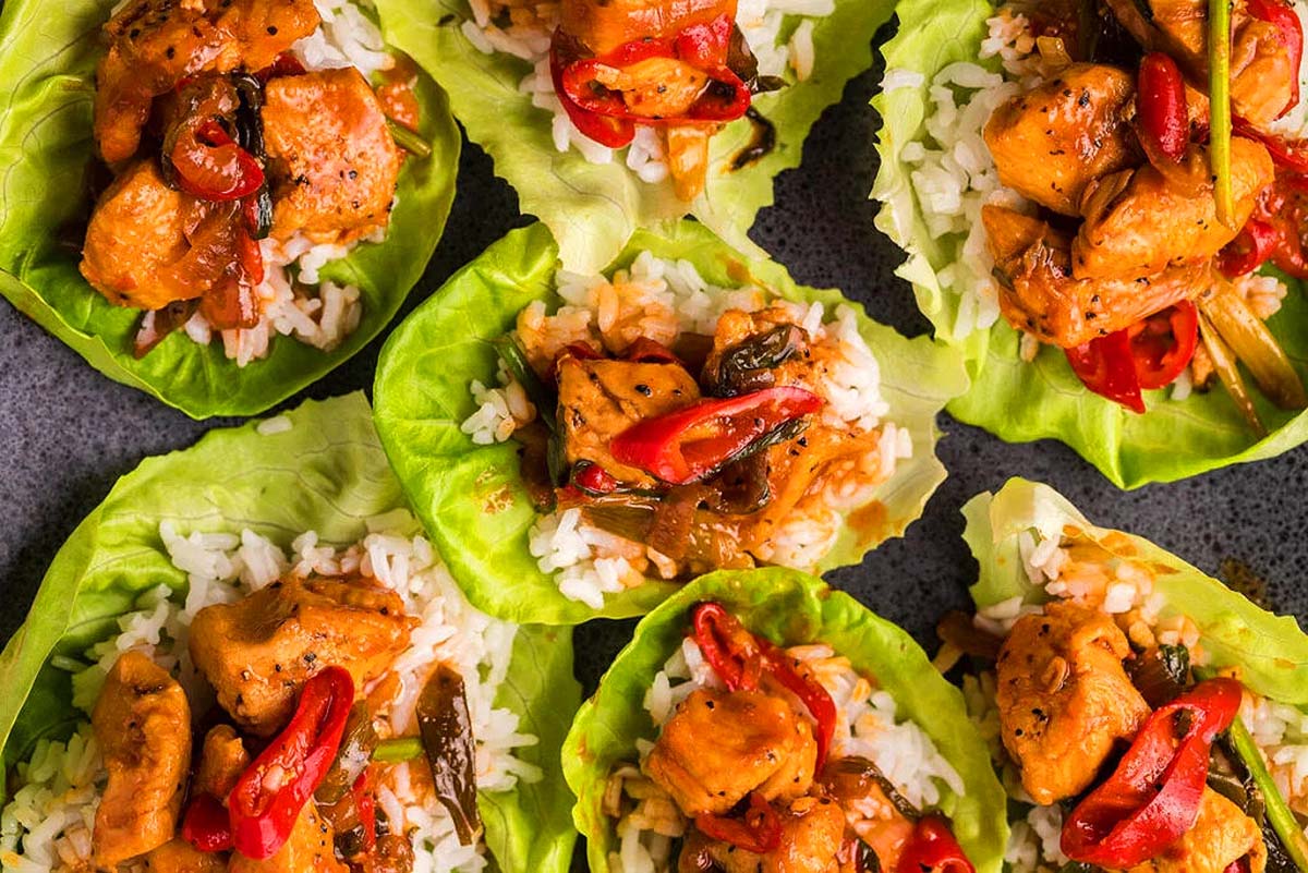 Spicy gochujang chicken stir fry served on lettuce leaves.
