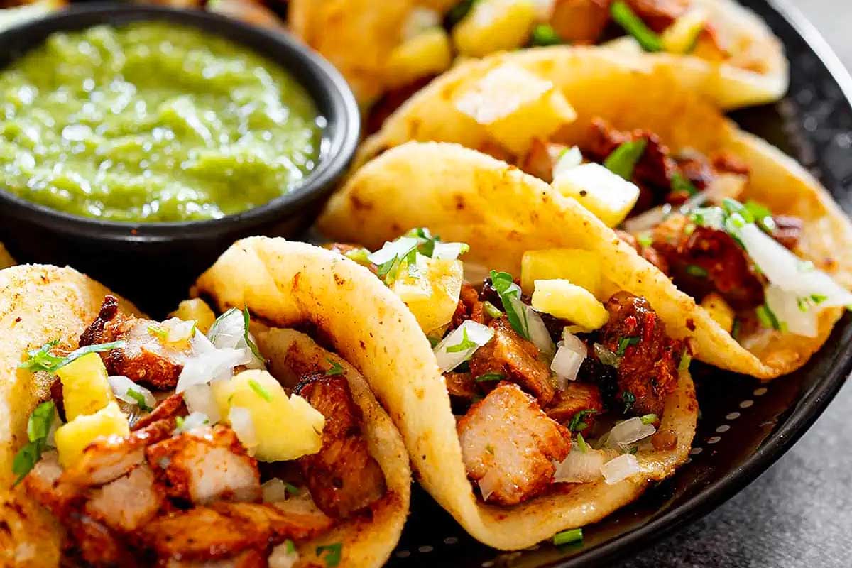 Chicken tacos with guacamole on a plate.
