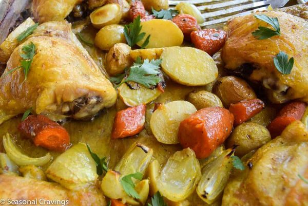 Roasted chicken with carrots and potatoes on a plate.