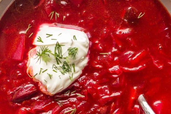A bowl of vegan borscht with sour cream.