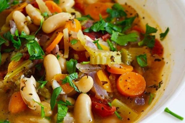 White bean soup in a white bowl.