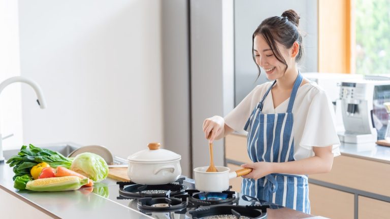 A woman cooking in a kitchen.