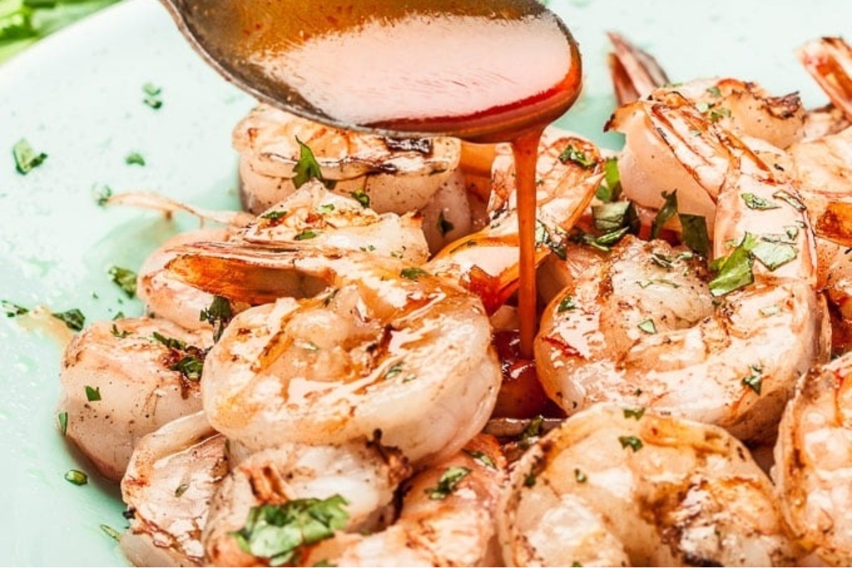 Grilled shrimp with sauce on a plate.
