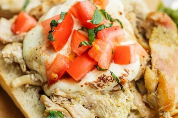A sandwich with chicken and tomatoes on it.