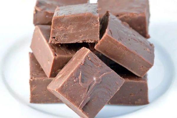A christmas-inspired pile of chocolate fudge on a white plate.
