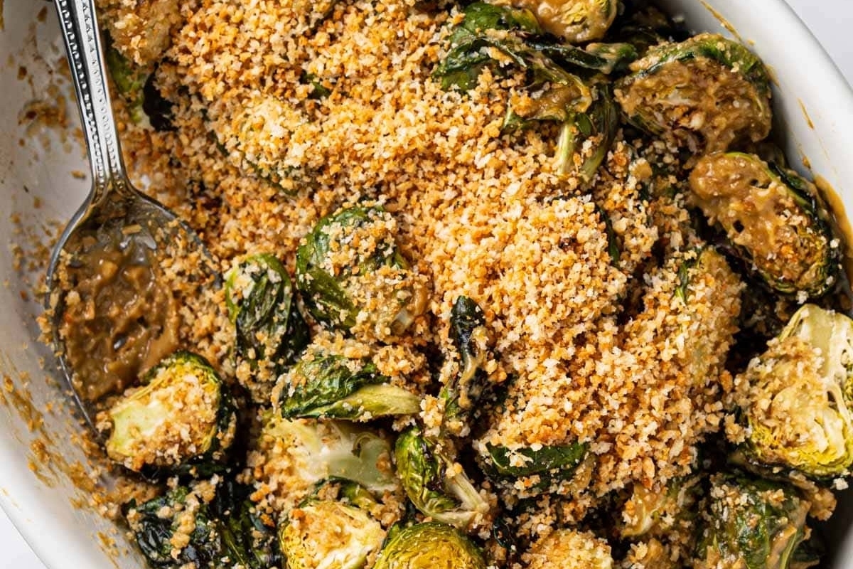Air-Fried Brussels sprouts in a white dish with a spoon.