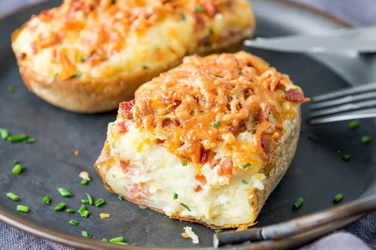 Two baked potatoes on a plate with a fork.