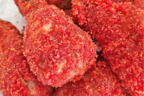 A close up of delicious red fried chicken on a plate, perfect for Game Day.