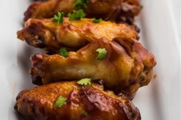Game Day Wings served on a white plate with barbeque sauce.