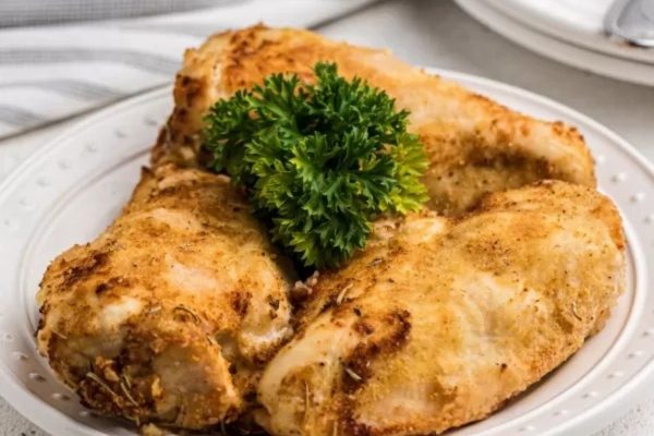 Chicken breasts on a white plate with parsley.