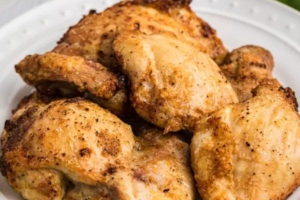 Chicken thighs on a white plate.