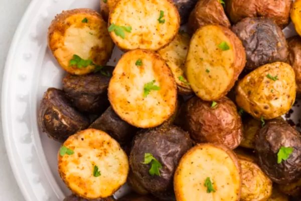 Roasted potatoes served as a side dish alongside turkey on a white plate.