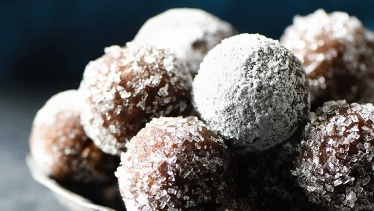 A silver bowl filled with sugared doughnuts.