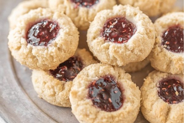 A plate of cookies with jam and jelly on it.
