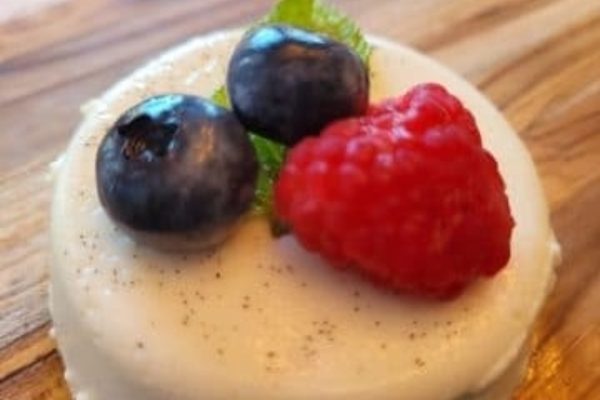 A white cake with blueberries and mint on top, perfect for summer recipes.