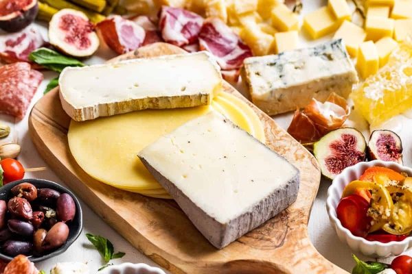 A festive charcuterie board featuring various types of cheese beautifully arranged for Christmas.
