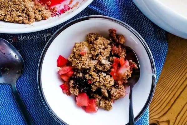 A bowl of berries and granola with a spoon.