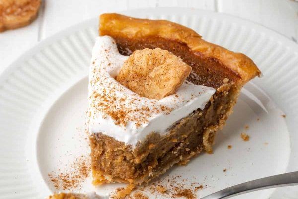 A slice of pumpkin pie on a white plate.