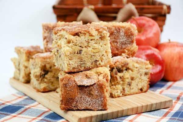 A stack of apple cake on a wooden cutting board, perfect for those looking for delicious desserts or unique baking recipes.