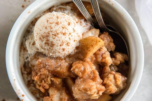 Apple crisp in a bowl with ice cream.