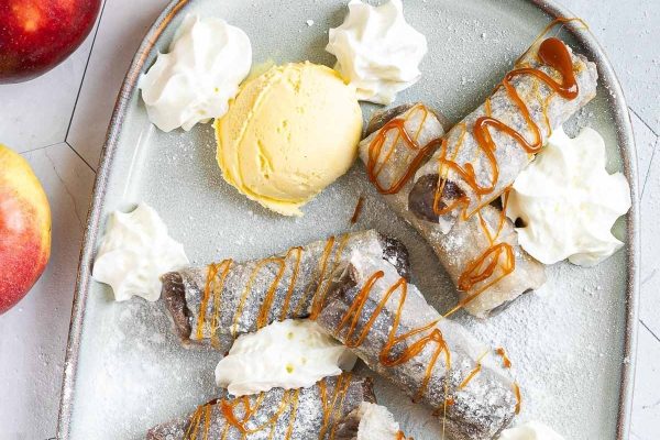 A plate topped with ice cream and apple slices.