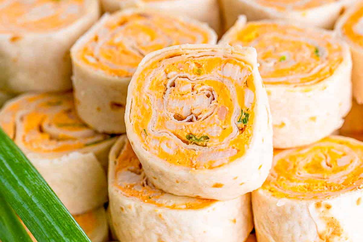 A plate of rolls with chicken and vegetables on it.