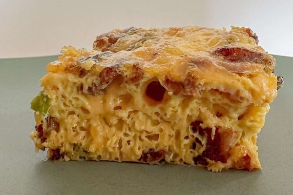 A piece of cheese and bacon casserole on a plate.