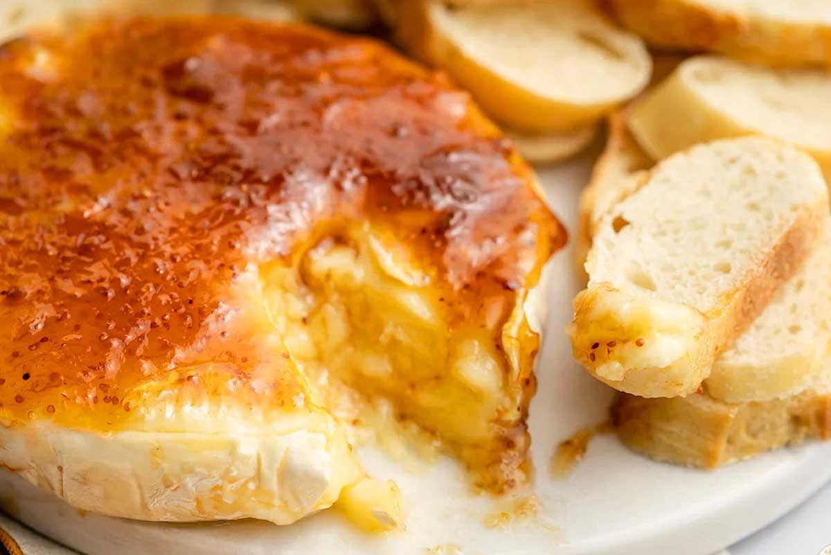 A plate of cheese and bread on a white plate.