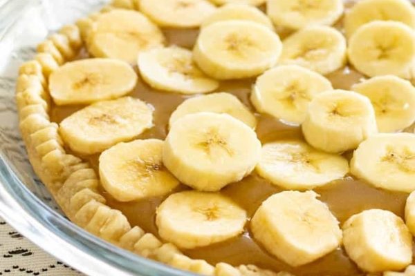 A pie filled with banana slices and caramel.