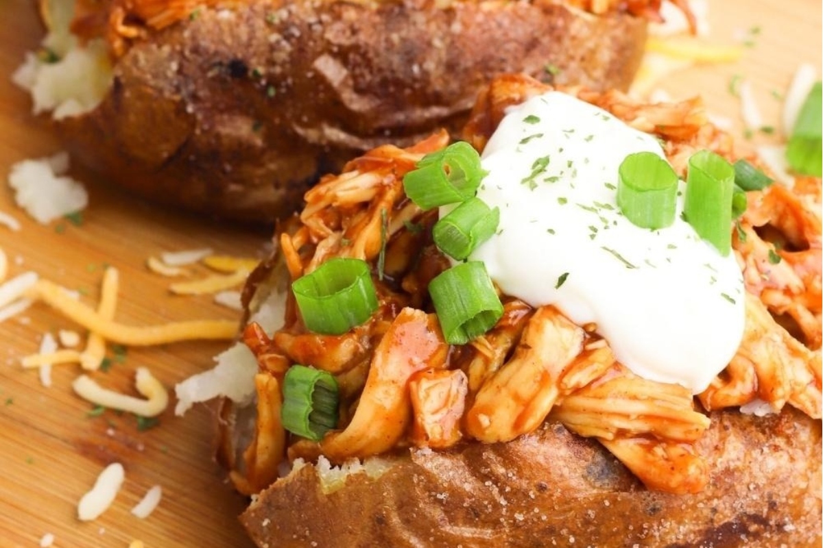 Two baked potatoes topped with leftover turkey and sour cream.