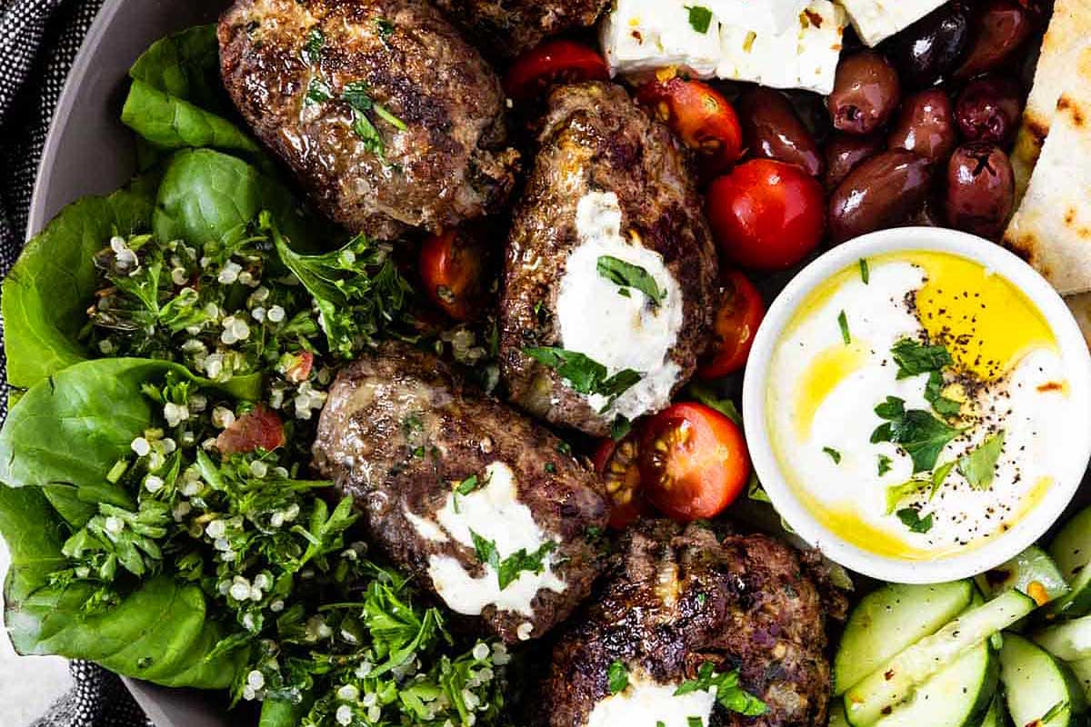 Gyro meatballs with tzatziki sauce on a plate.