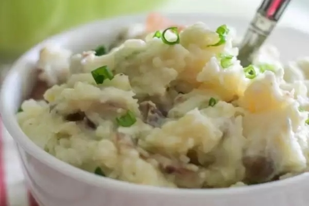 Cheap mashed potatoes in a white bowl with a spoon.